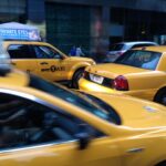 yellow taxi cars moving through downtown traffic