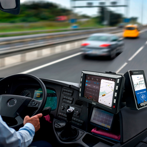 bus driver operating an atomo 10 ets all-in-one console with touchscreen display and mobile device while driving on the highway
